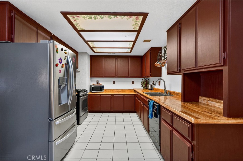 4153 North Webster Avenue Perris, CA 92571 - Photo 9 of 49 a kitchen with stainless steel appliances granite countertop a refrigerator and a stove