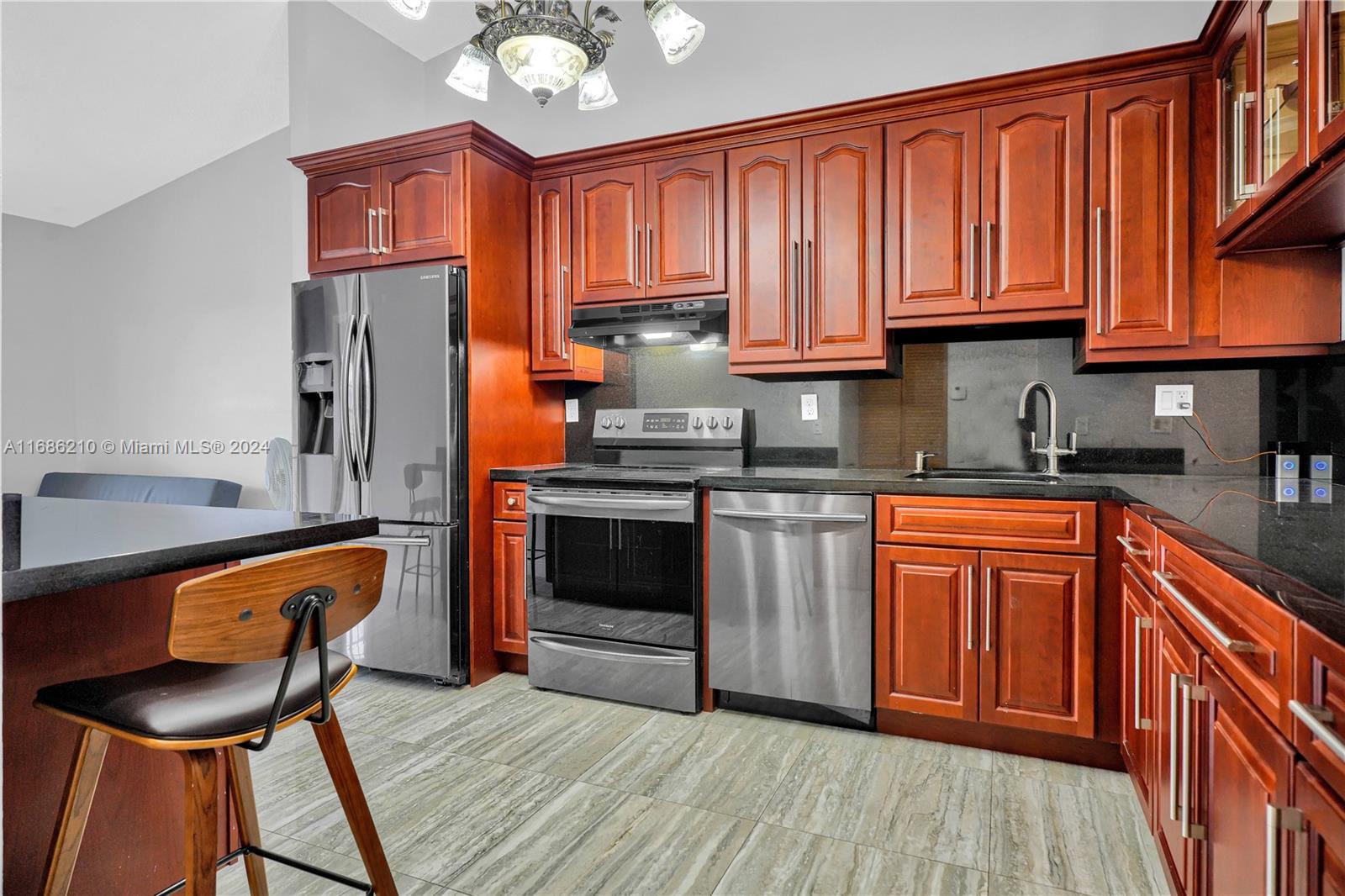 7462 West 29th Way Hialeah, FL 33018 - Photo 2 of 13 a kitchen with stainless steel appliances granite countertop wooden cabinets a stove top oven a sink and dishwasher