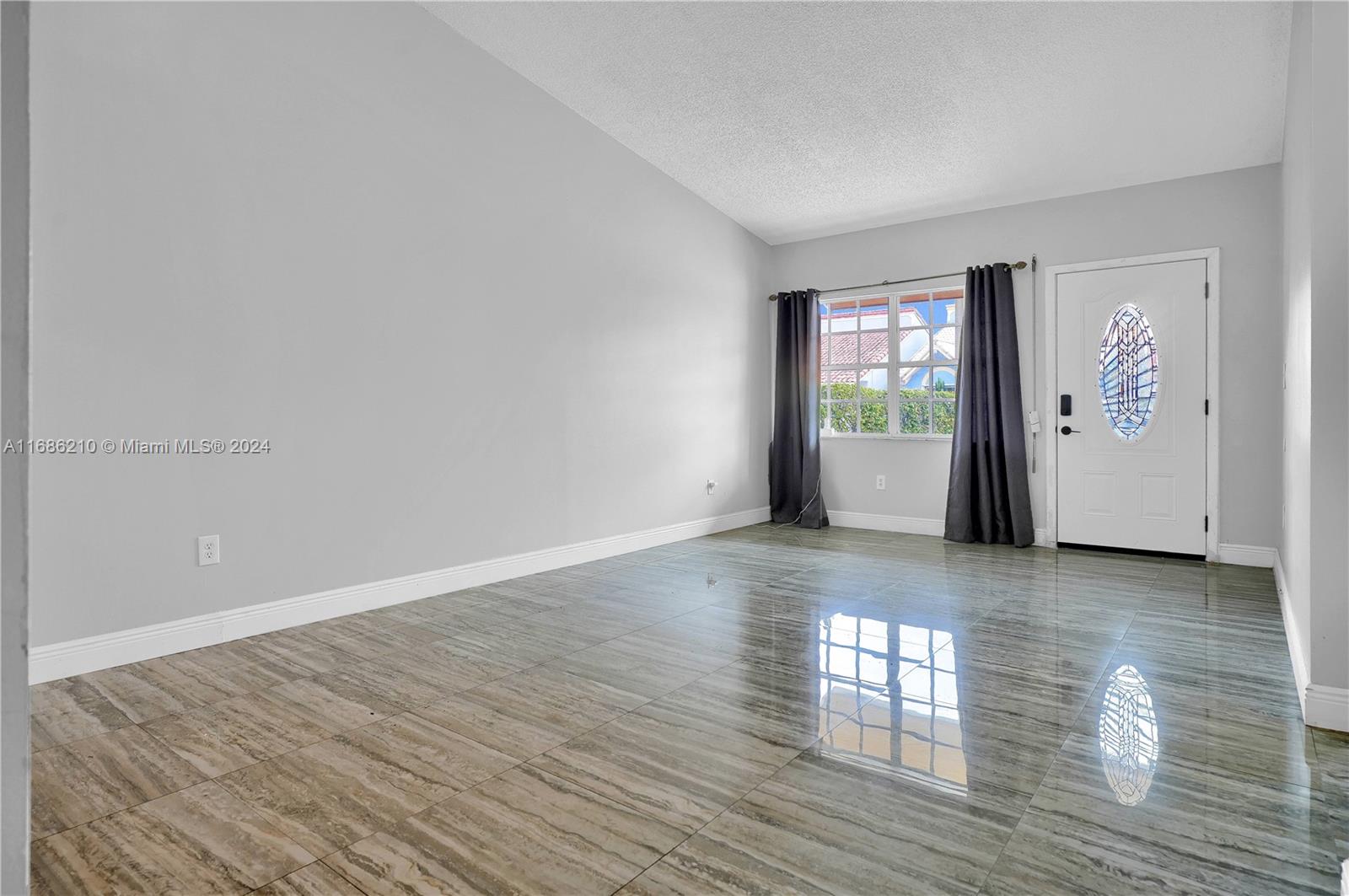 7462 West 29th Way Hialeah, FL 33018 - Photo 3 of 13 a view of an empty room with wooden floor and a window