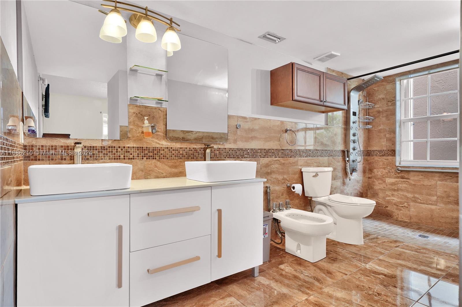 7462 West 29th Way Hialeah, FL 33018 - Photo 7 of 13 a bathroom with a toilet a sink and a mirror