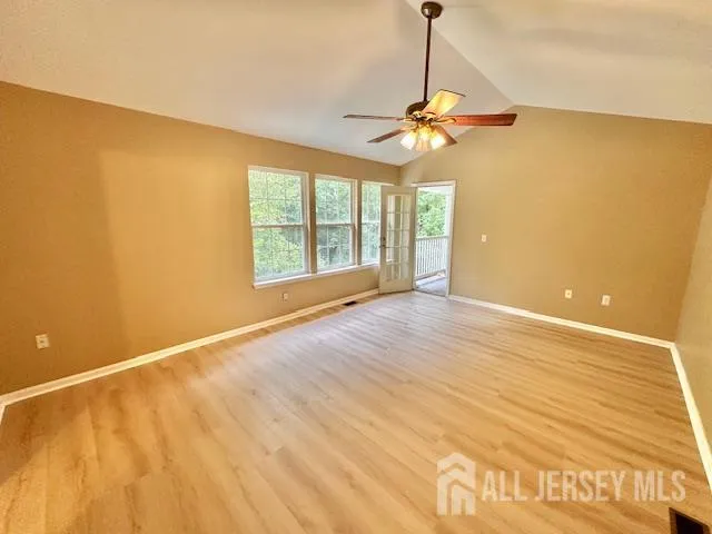 a view of a hallway with wooden floor and a ceiling fan