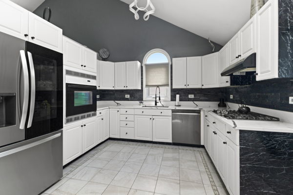 24222 Volbrecht Road Crete, IL 60417 - Photo 5 of 16 a kitchen with white cabinets and white appliances