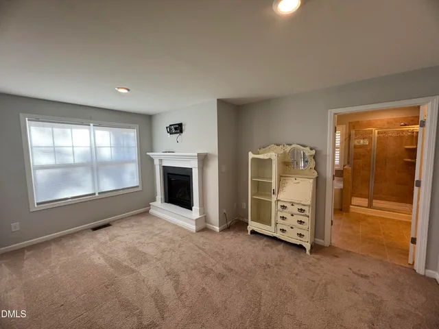 an empty room with fireplace and windows