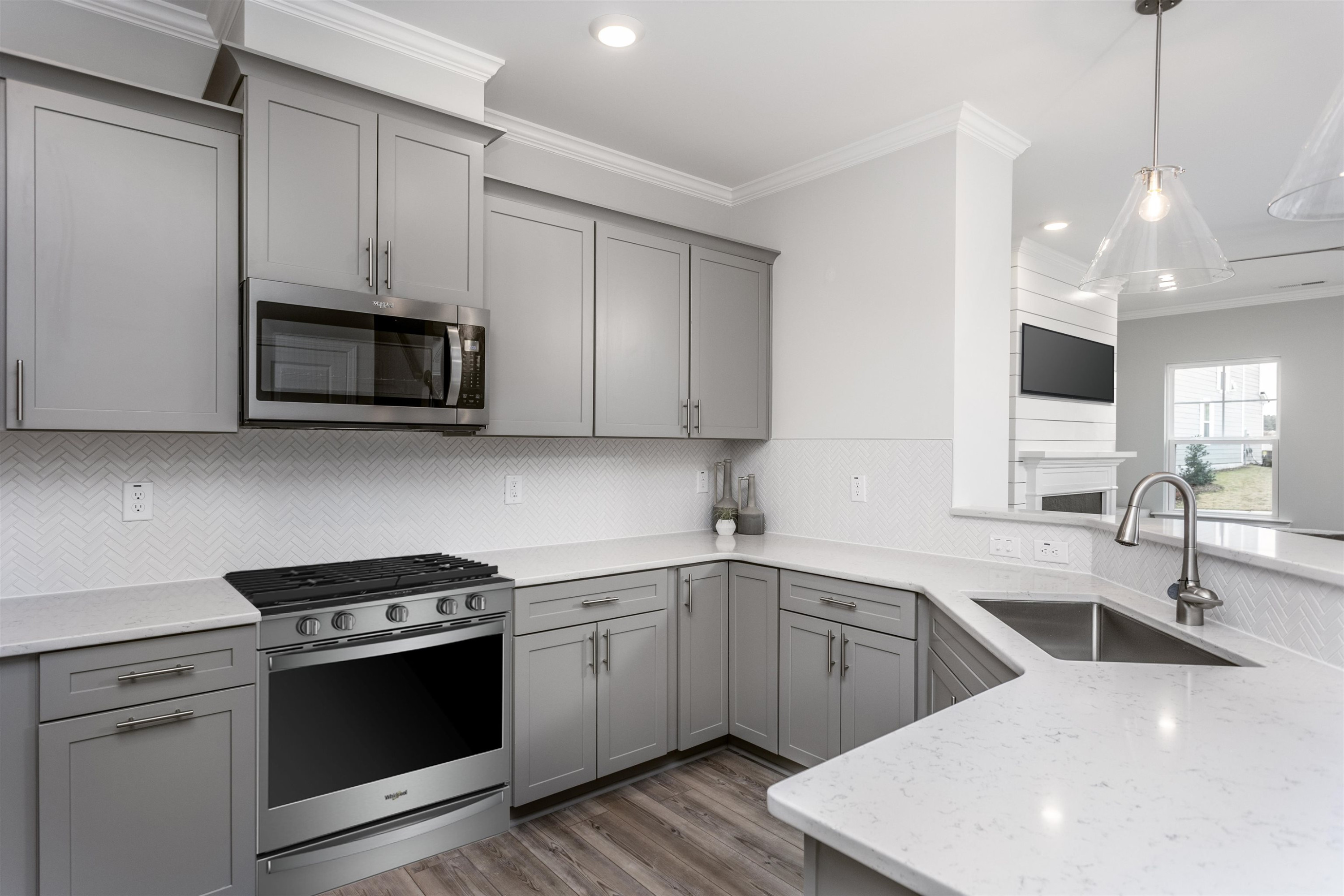 5701 Preveza Place Raleigh, NC 27603 - Photo 9 of 21 a kitchen with stainless steel appliances a sink a stove a microwave and wooden cabinets