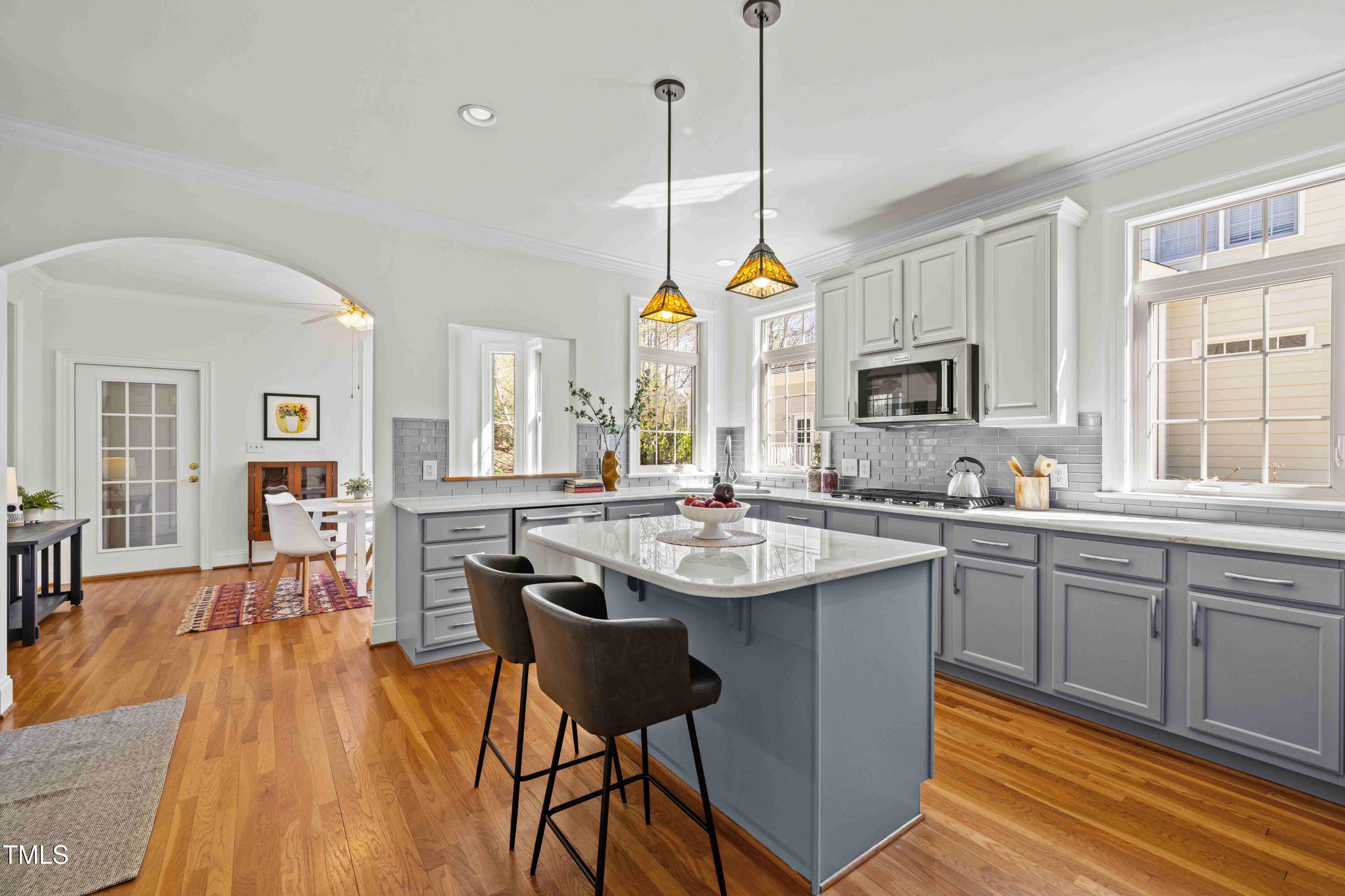 10040 Ward Chapel Hill, NC 27517 - Photo 16 of 56 a kitchen with stainless steel appliances granite countertop a stove a sink dishwasher a dining table and chairs with wooden floor