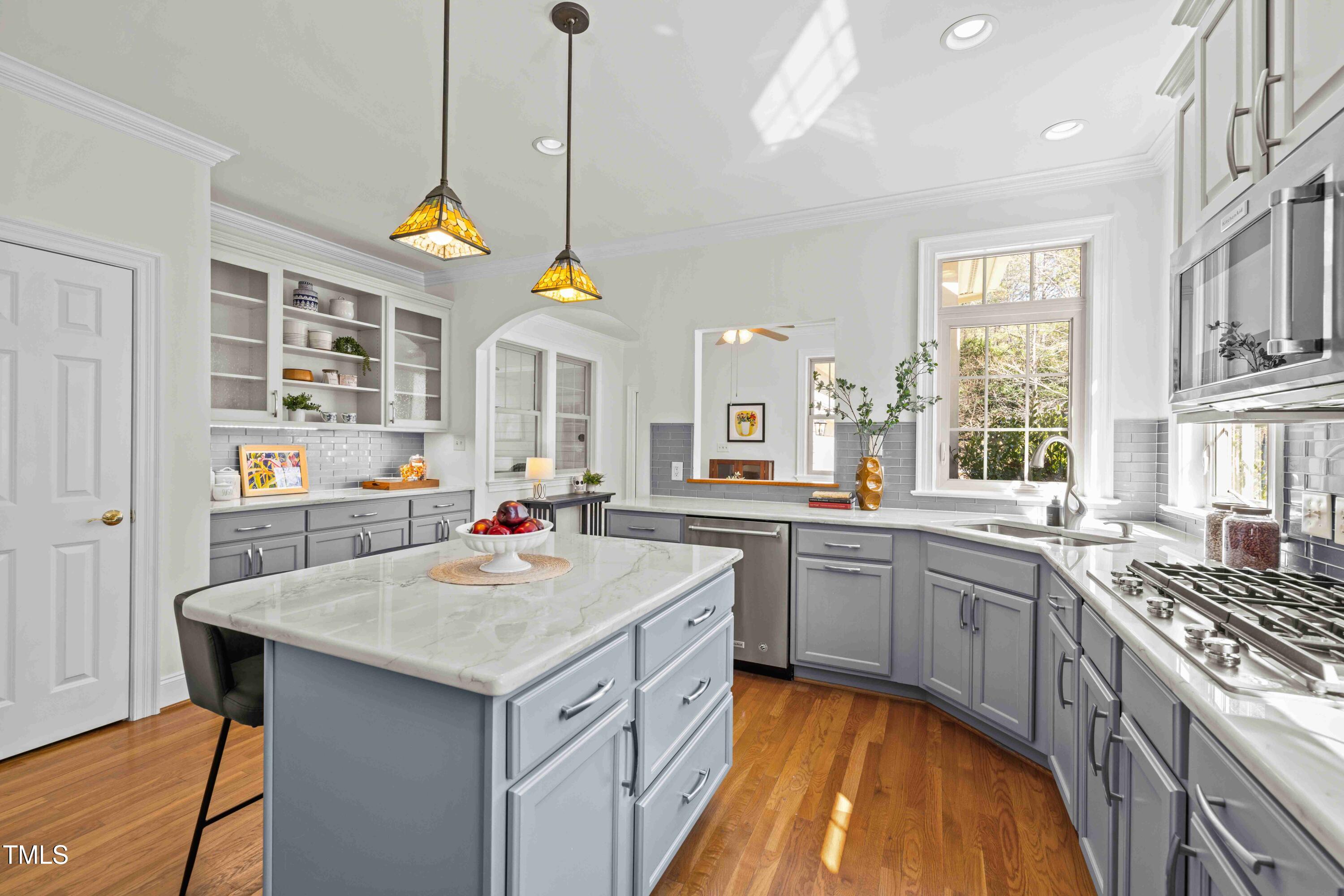 10040 Ward Chapel Hill, NC 27517 - Photo 19 of 56 a kitchen with a stove a sink a center island and wooden floor