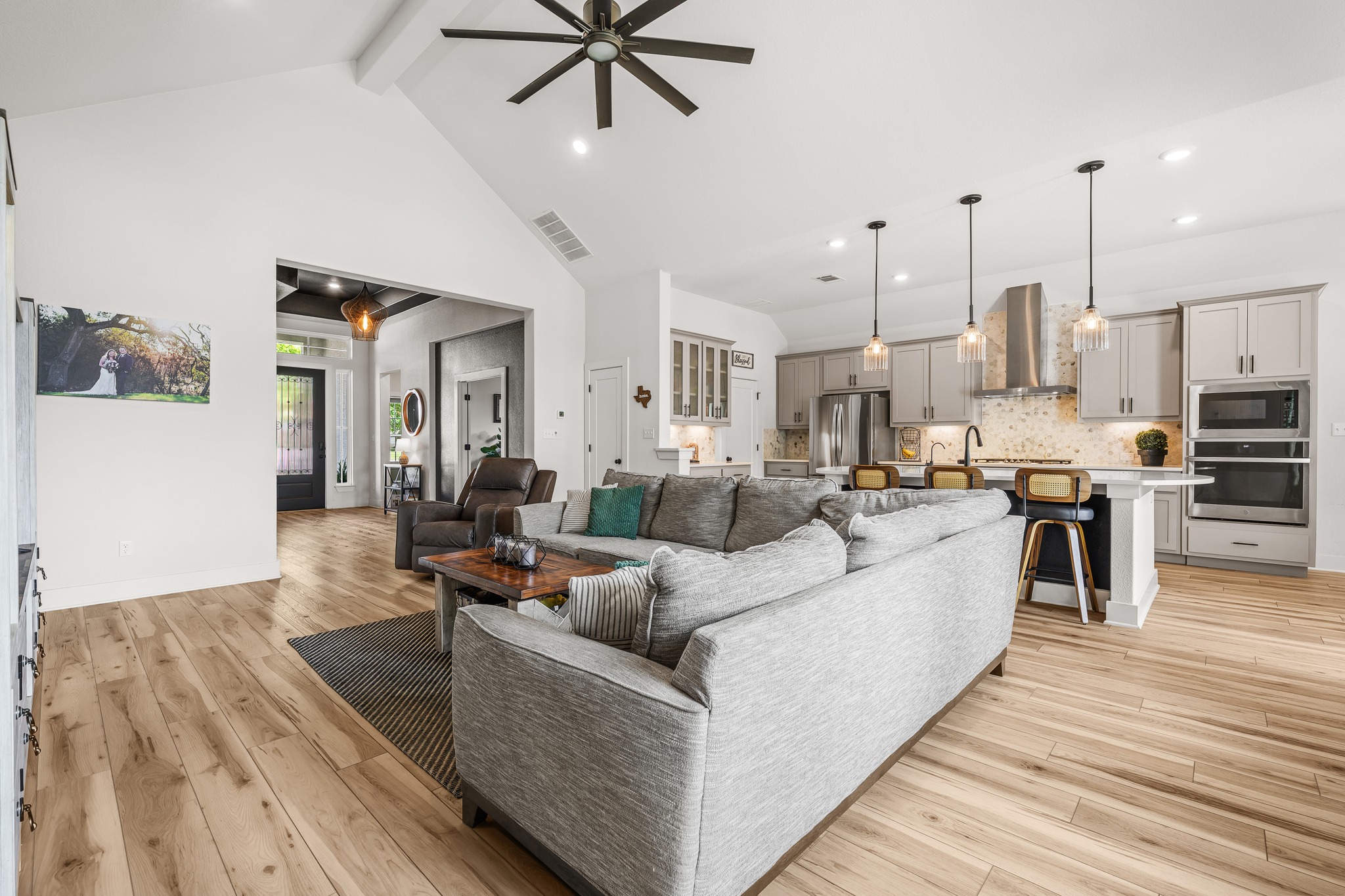 68 Rancho Trail Georgetown, TX 78628 - Photo 7 of 39 An open-concept interior features soaring vaulted ceilings, and a modern kitchen with pendant lighting.