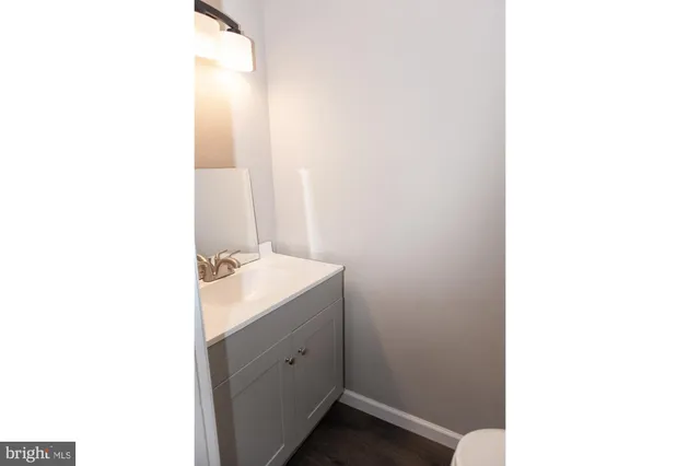 a white toilet sitting next to a white cabinet