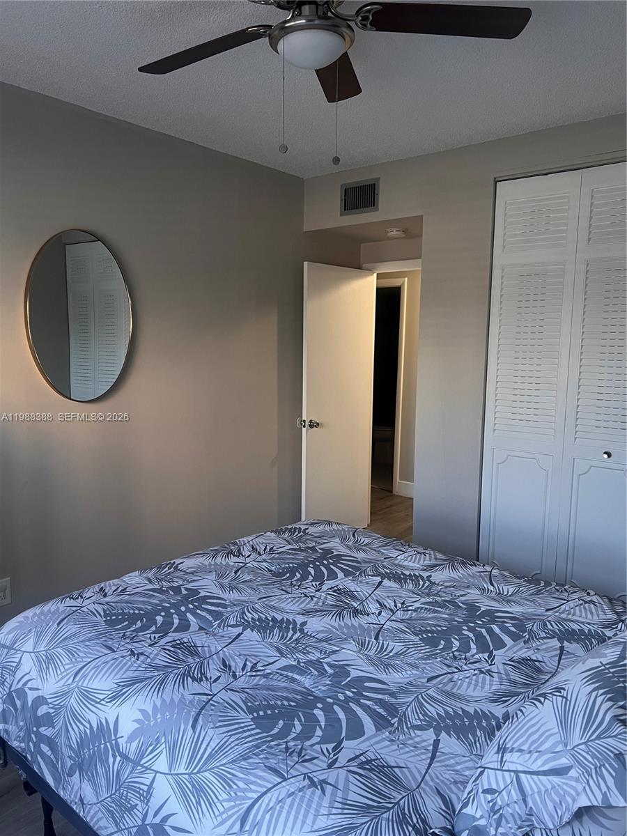 400 North Riverside Drive, Unit 214 Pompano Beach, FL 33062 - Photo 20 of 67 a bedroom with a bed and a chandelier