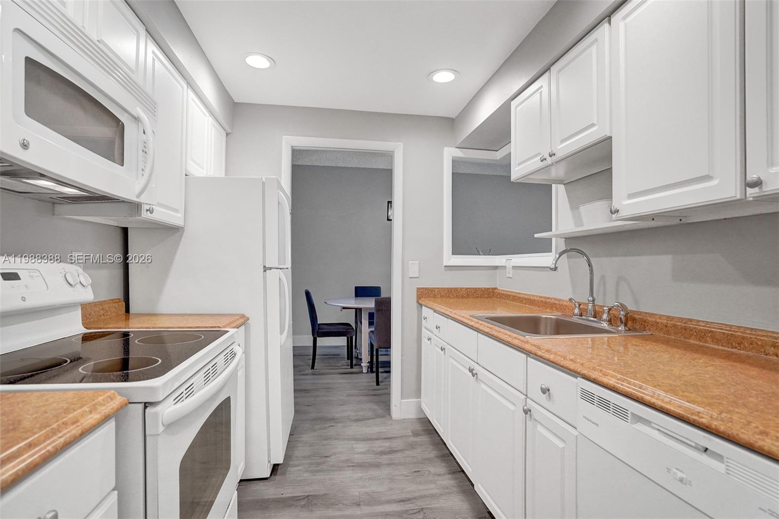 400 North Riverside Drive, Unit 214 Pompano Beach, FL 33062 - Photo 2 of 67 a kitchen that has a sink and a stove in it