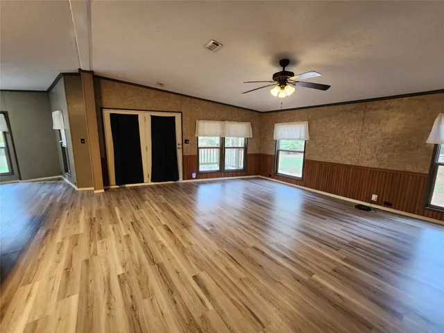 a view of an empty room with wooden floor
