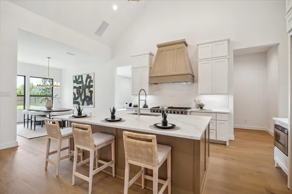 a kitchen with a dining table chairs stove and cabinets