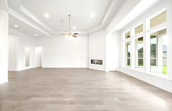 an empty room with a ceiling fan and a window