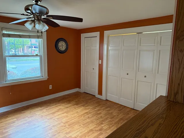 a view of empty room with window and wooden floor