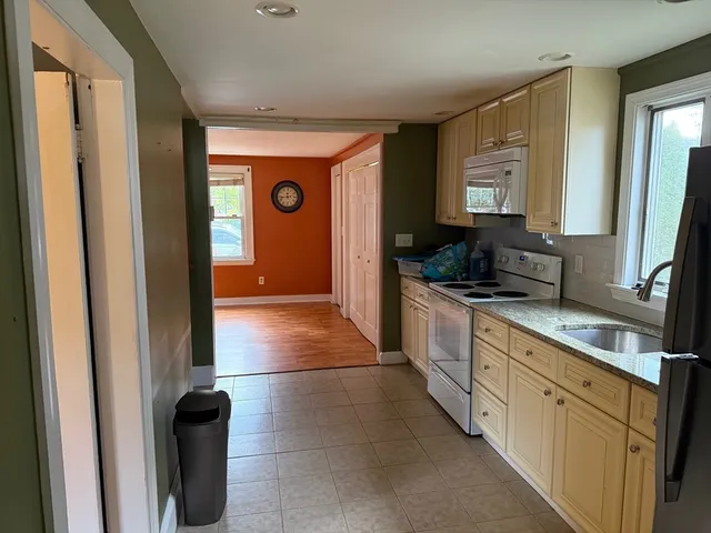 a large kitchen with a sink and a large window