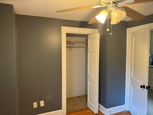a view of a hallway with a chandelier fan