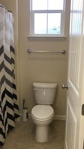 a bathroom with a toilet and a window
