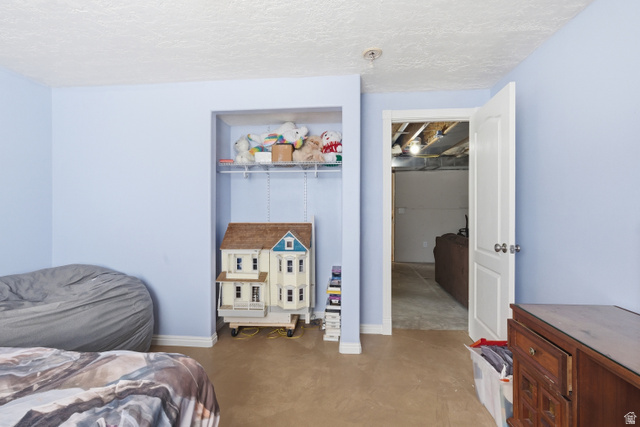 860 West 2980th Street South Logan, UT 84321 - Photo 31 of 38 Room featuring light blue walls, textured ceiling, and an open doorway leading to an unfinished space