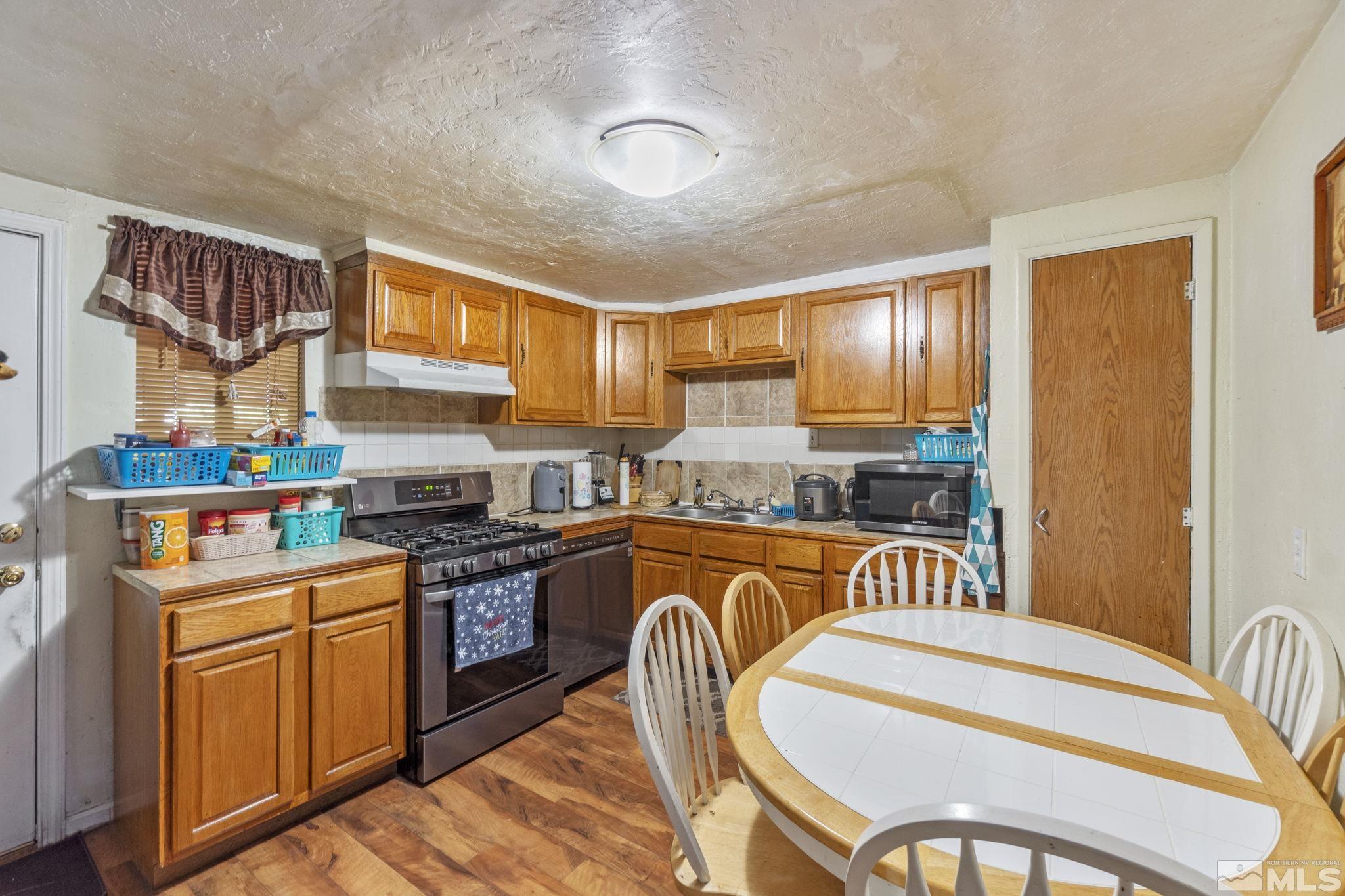 1905 Citron Street Reno, NV 89512 - Photo 4 of 18 a kitchen with stainless steel appliances granite countertop a stove a sink dishwasher and cabinets with wooden floor