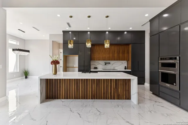 a large kitchen with a large counter top sink stainless steel appliances and cabinets