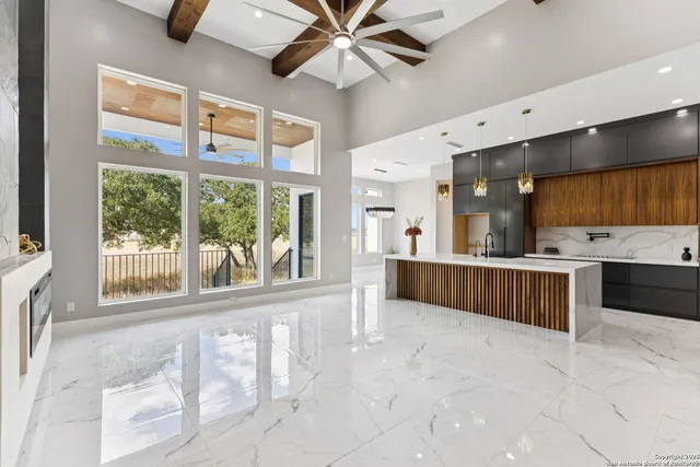 a large kitchen with stainless steel appliances kitchen island granite countertop a refrigerator and a sink