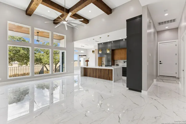 a view of an empty room with kitchen view and a window