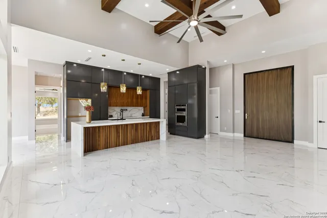 a open kitchen with stainless steel appliances kitchen island granite countertop a refrigerator and a sink