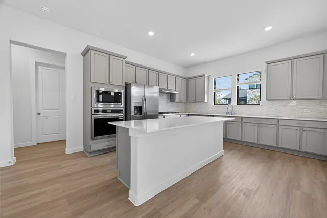 a kitchen with white cabinets and stainless steel appliances