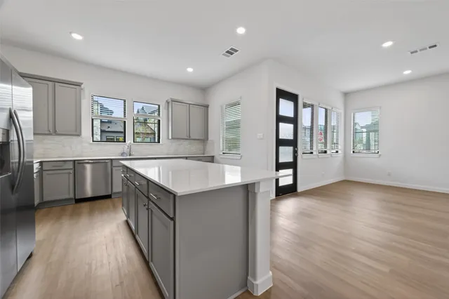 a kitchen with granite countertop a sink cabinets and wooden floor