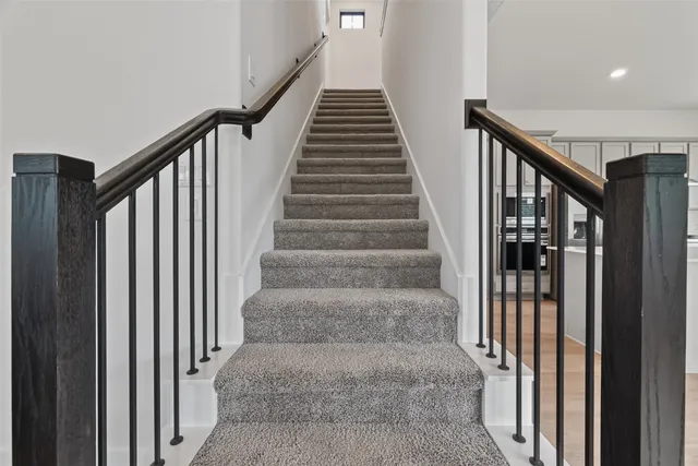a view of staircase with lots of frames on wall and windows