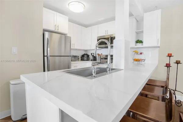 a kitchen with sink a refrigerator and a stove top oven