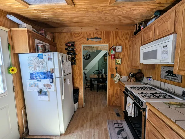 a kitchen with a refrigerator a stove and wooden floor