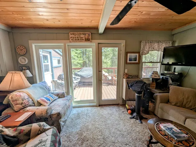 a living room with furniture a flat screen tv and a large window