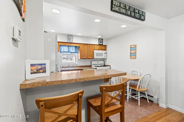 a kitchen with refrigerator a stove a sink cabinets and a dining table