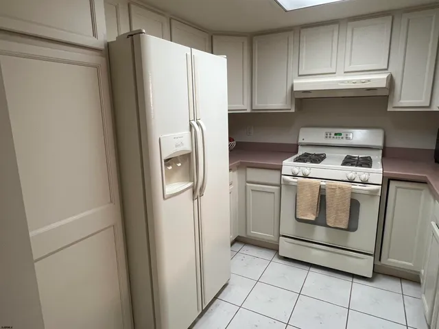 a kitchen with a stove a refrigerator and cabinets