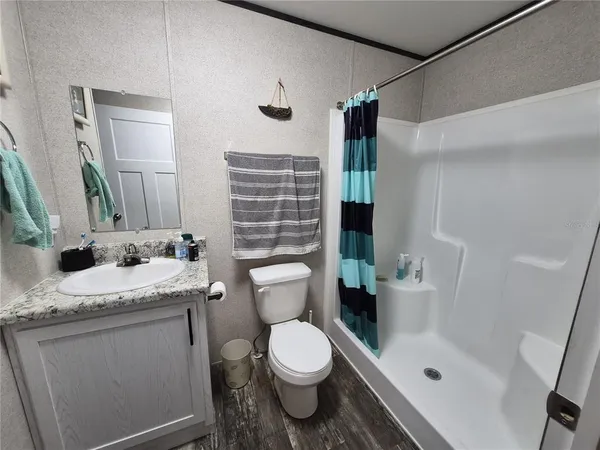 a bathroom with a granite countertop sink toilet and shower