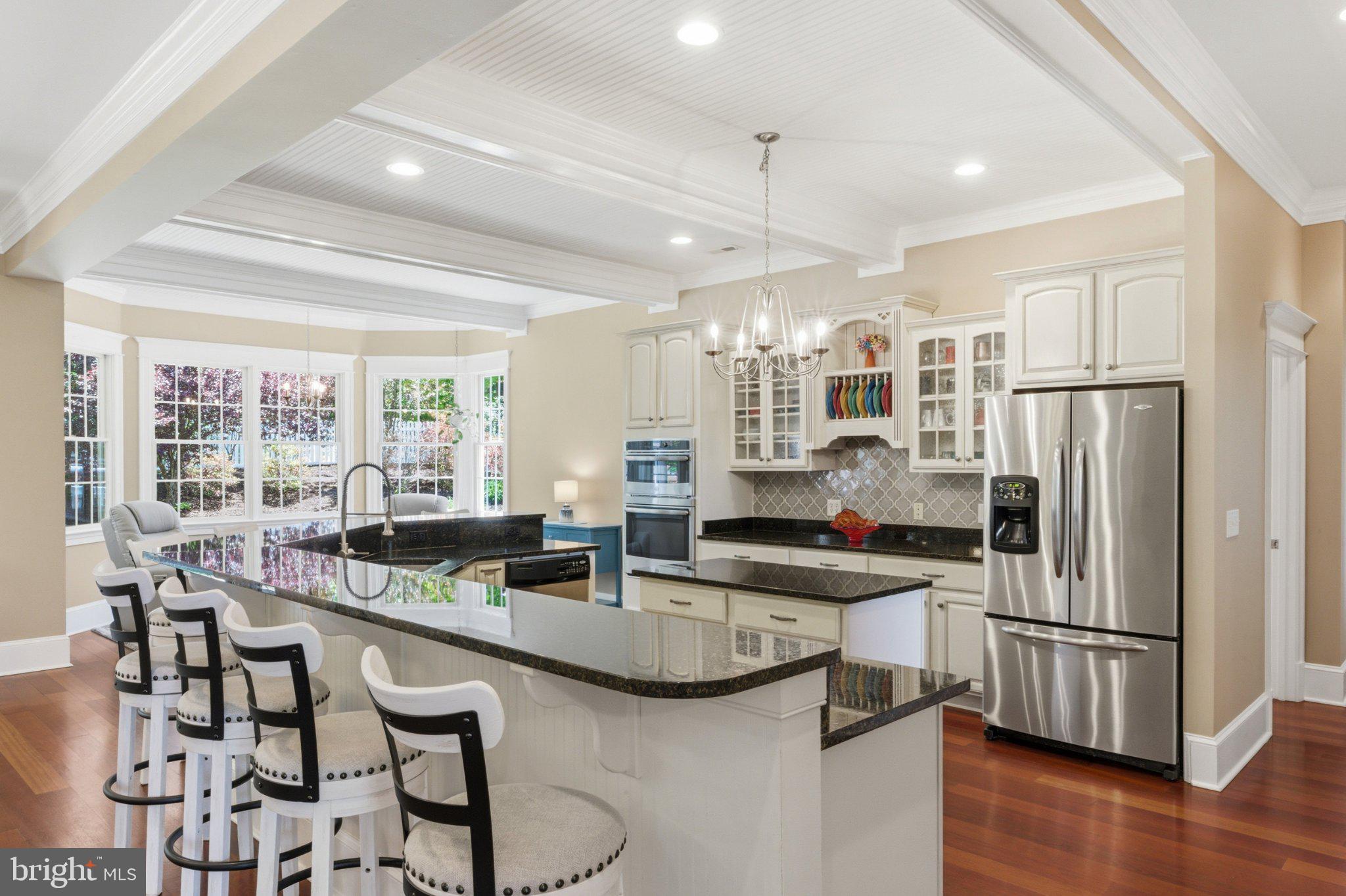 246 Lawsons Farm Circle Ruckersville, VA 22968 - Photo 11 of 130 a kitchen with stainless steel appliances granite countertop a stove refrigerator a dining table and chairs with wooden floor
