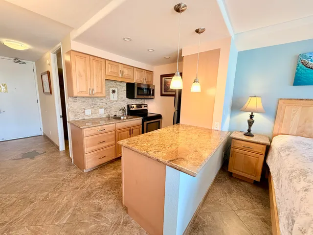 a kitchen with stainless steel appliances granite countertop a sink stove and refrigerator