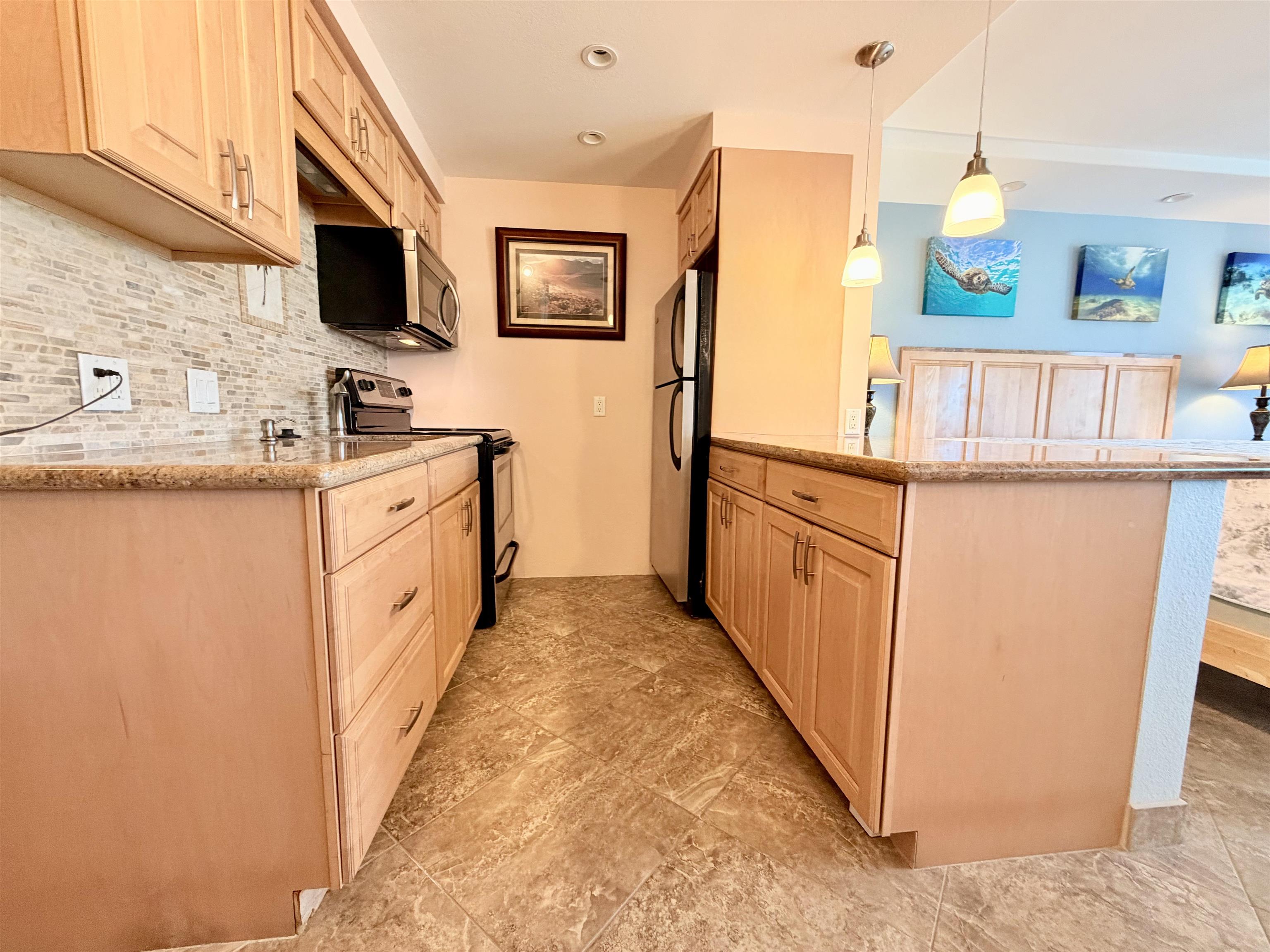 475 Front Street, Unit 320 Lahaina, HI 96761 - Photo 5 of 41 a kitchen with stainless steel appliances a stove refrigerator sink and microwave