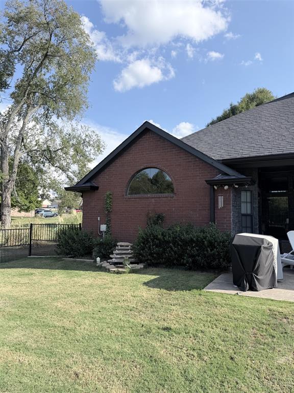 313 An County Road, Unit 2145 Palestine, TX 75801 - Photo 20 of 40 Brick exterior with a gabled roofline, semicircular window, and a stone water feature