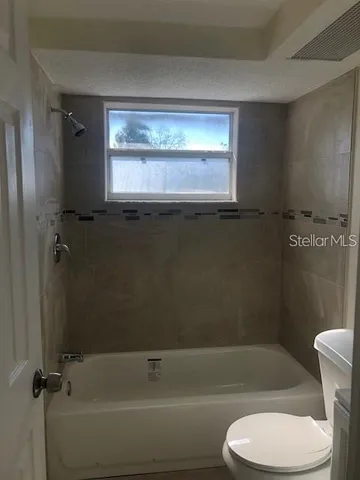 a bathroom with a toilet bathtub and shower