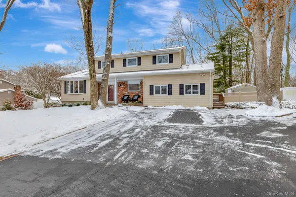 a view of a white house with a yard covered in snow
