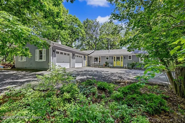 a front view of a house with a yard and trees