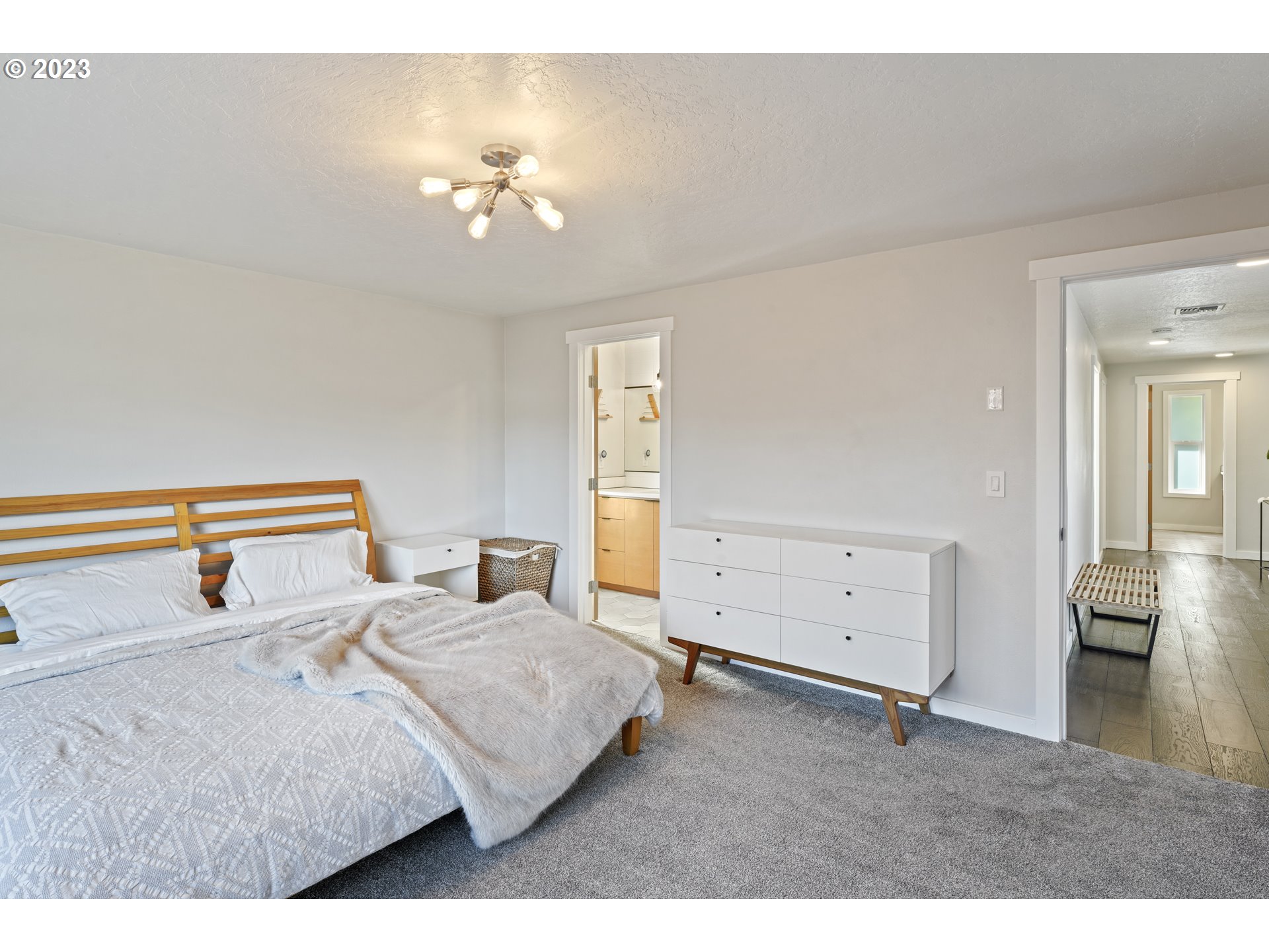 2180 9th Street Springfield, OR 97477 - Photo 16 of 32 a bedroom with a large bed and a chandelier