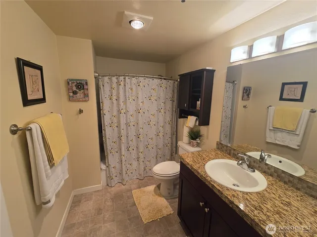 a bathroom with a granite countertop sink toilet and shower
