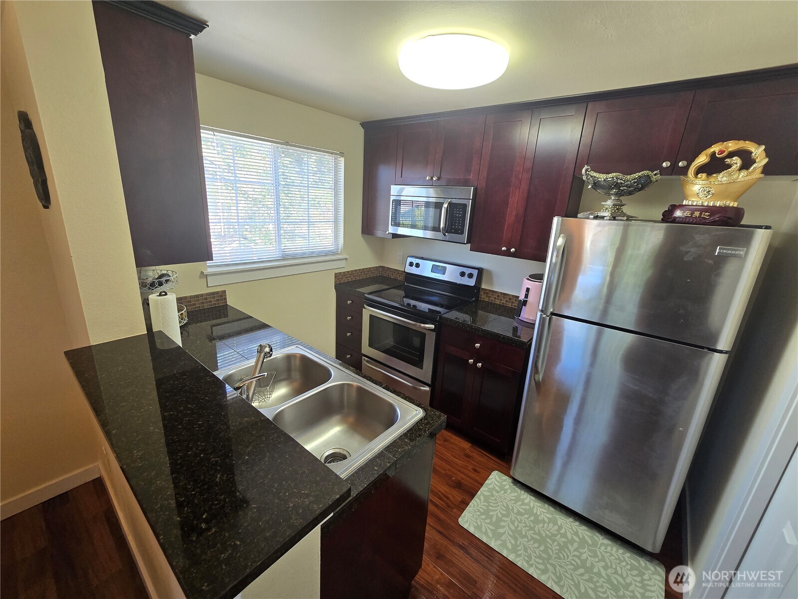1840 South 284th Lane, Unit H204 Federal Way, WA 98003 - Photo 7 of 14 a kitchen with stainless steel appliances granite countertop a refrigerator stove top oven dining table and chairs
