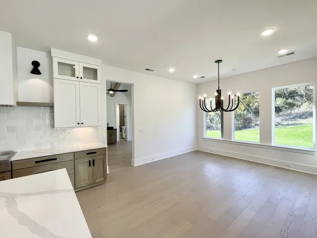 a view of an empty room with a fireplace and windows