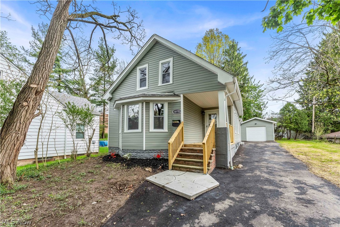 18155 Libby Road Maple Heights, OH 44137 - Photo 1 of 32 Sage green siding exterior with white trim and a covered front porch featuring natural wood railings and steps