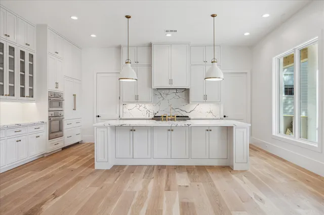 a large white kitchen with cabinets