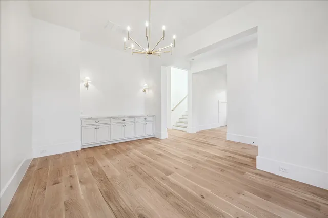 an empty room with wooden floor and ceiling fan